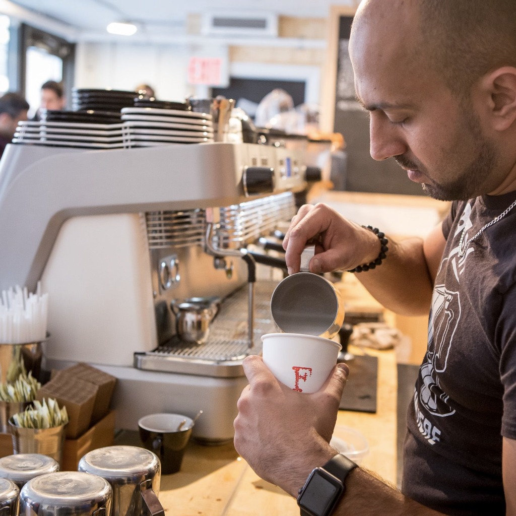 Fahrenheit Barista pouring milk into espresso